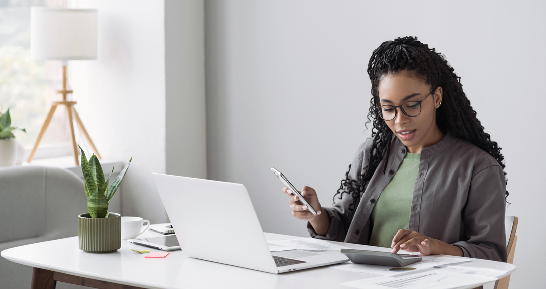 Businesswoman working on laptop and calculator